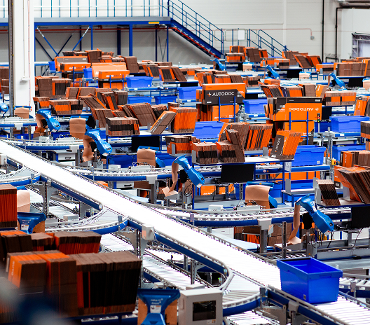 a large warehouse with blue and orange chairs