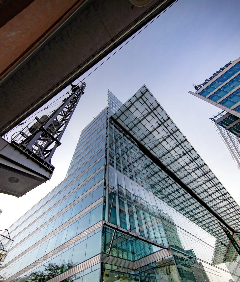 a tall glass building with a crane