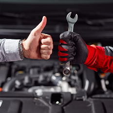 two hands holding a wrench and giving a thumbs up