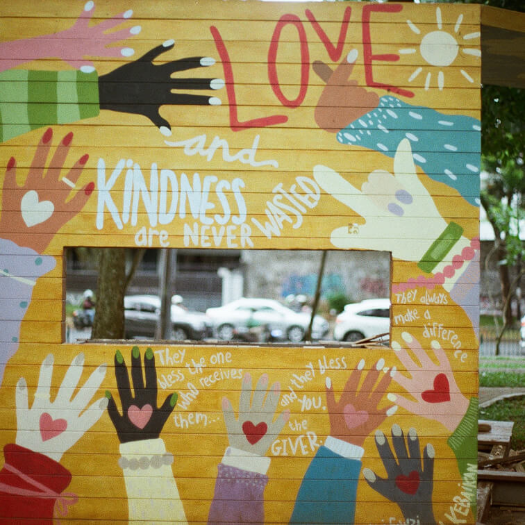 a yellow wall with painted hands and words